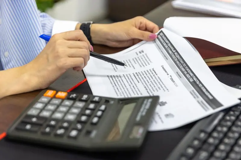 An accountant reviewing financial documents and reports at an office desk
