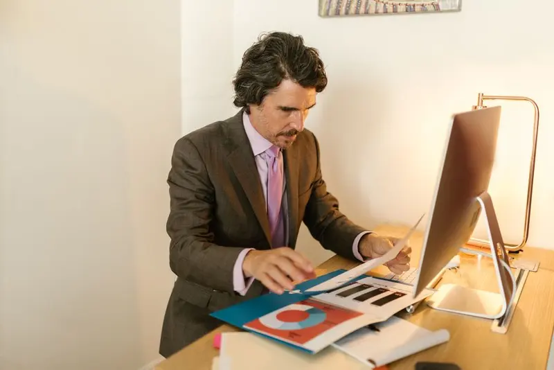 An administrator reviewing figures on a computer in an office