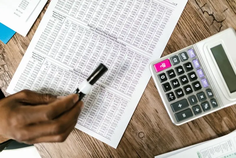 An accountant working through spreadsheets and paperwork with a calculator