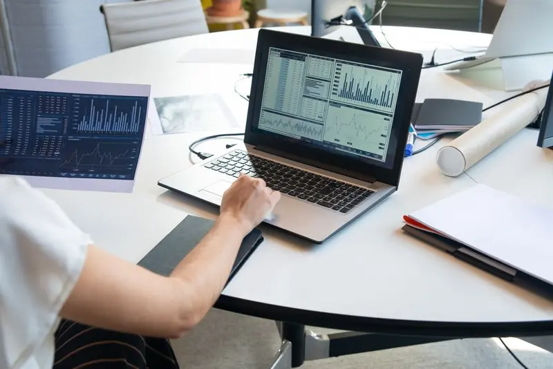 A person working with data on a laptop in an office